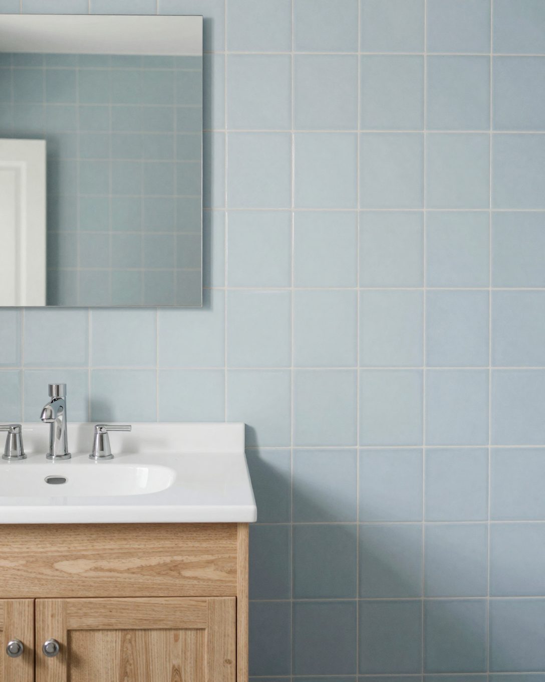 Illustration: a soft blue bathroom with powder blue gloss tiles and a white oak vanity