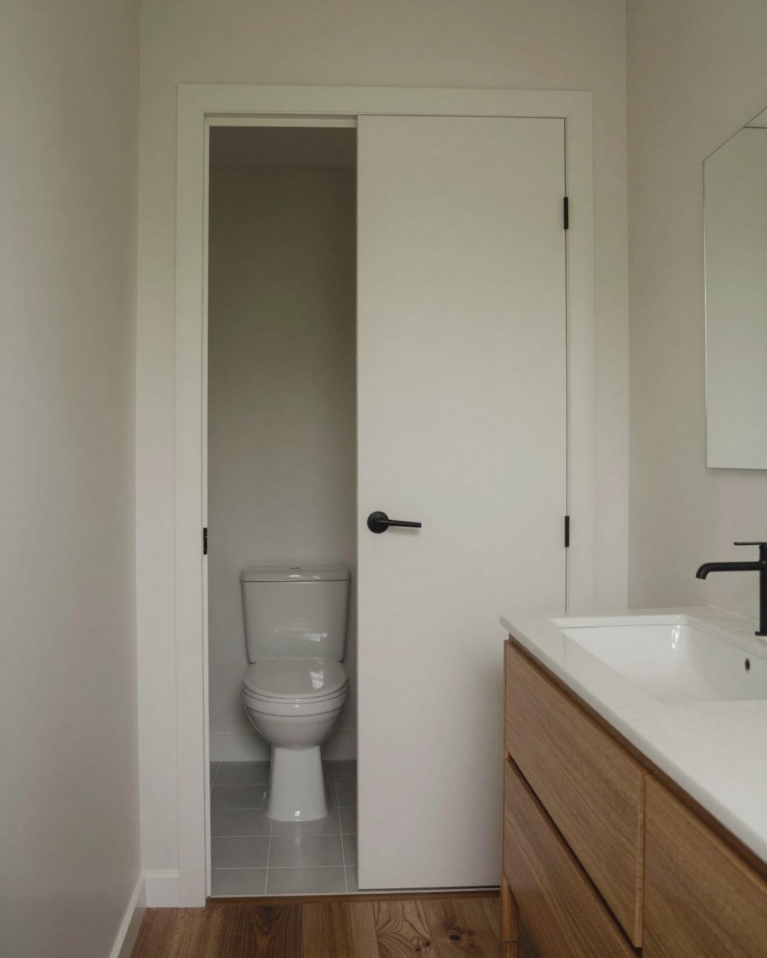 Illustration: an ensuite with the toilet in a separate small room behind a pocket door, a vanity in front